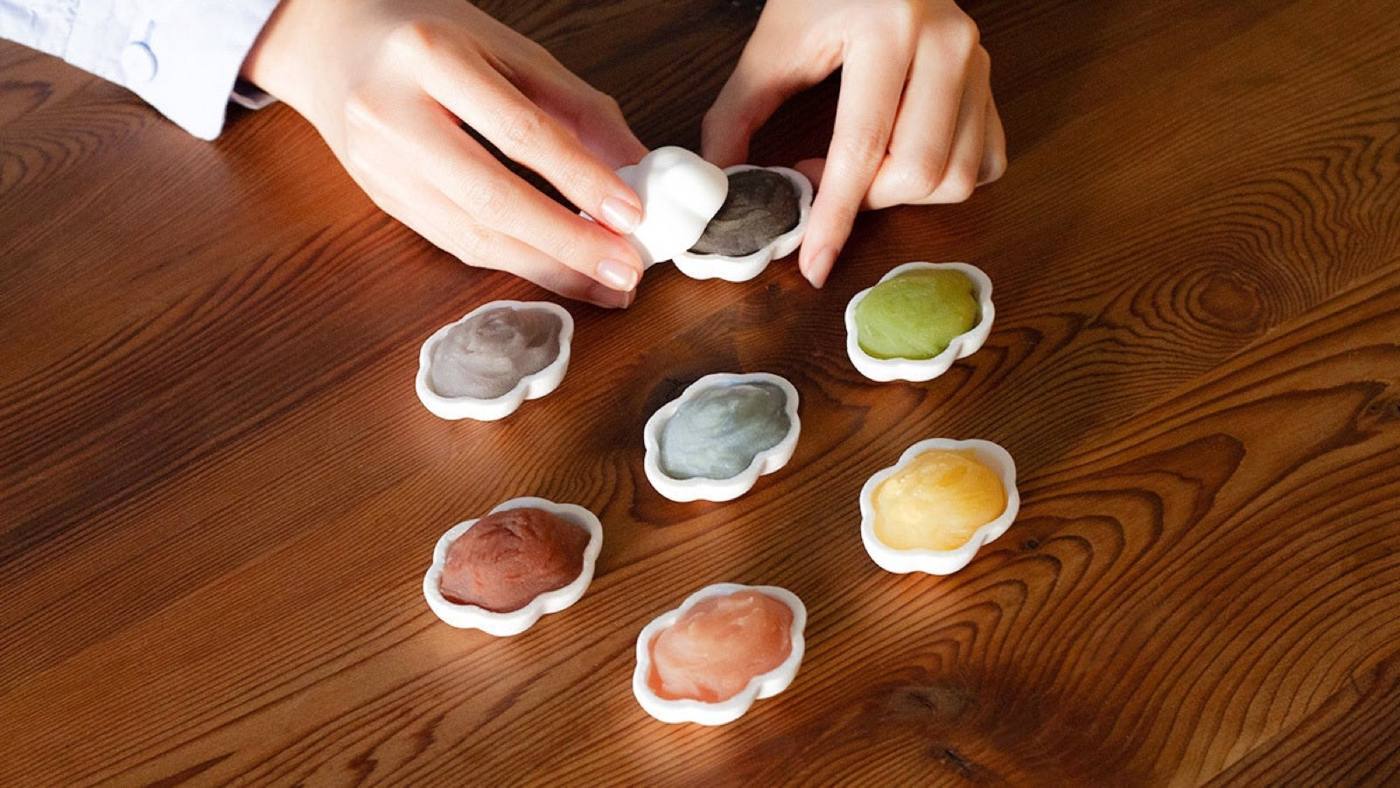 色をつけたあんをもなかに乗せる様子